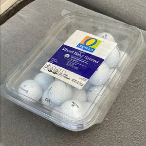 White Golf Balls in Plastic Container